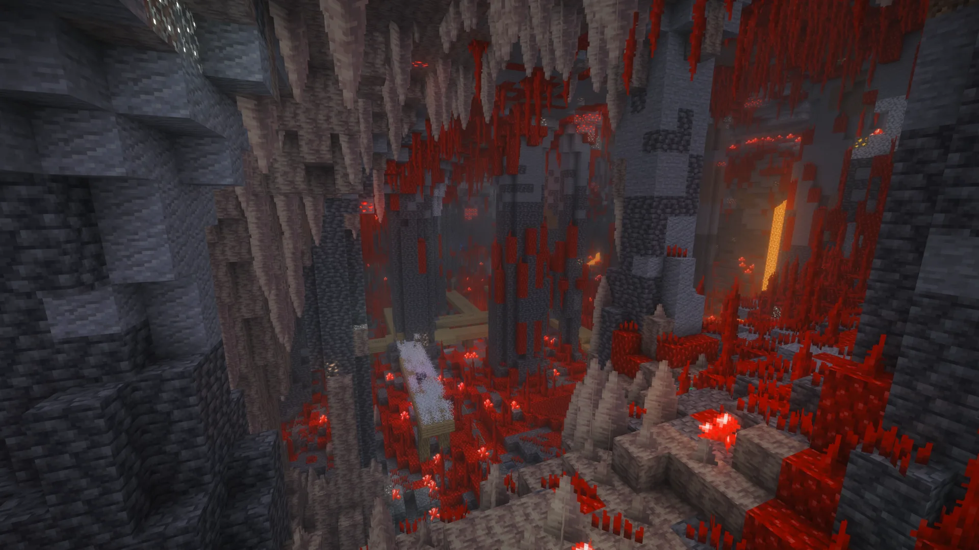 A deep stone cavern filled with red vegetation and lava